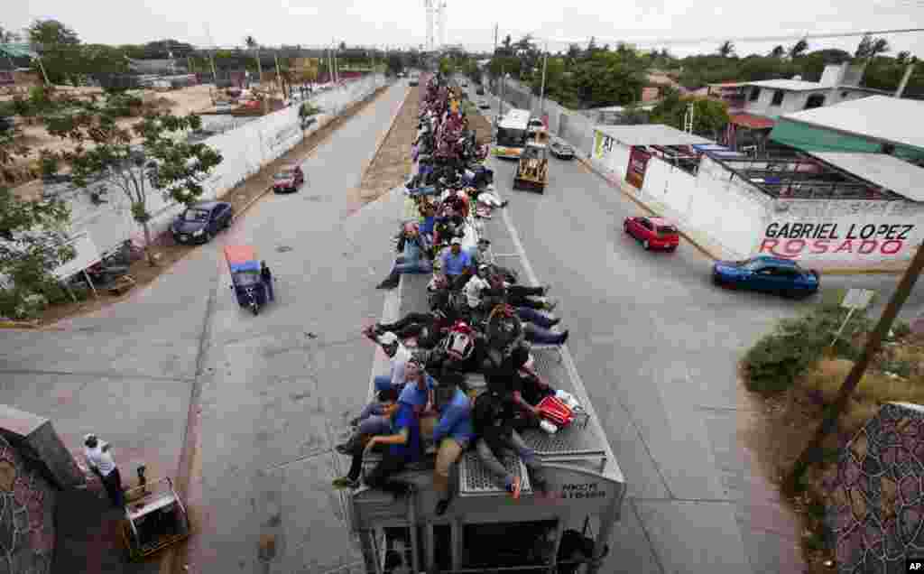 Para buruh migran Meksiko naik di atas atap kereta api di kota Juchitan, Meksiko, untuk menuju perbatasan AS-Meksiko. 