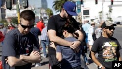 Reed Broschart, center, hugs his girlfriend Aria James on the Las Vegas Strip in the aftermath of a mass shooting at a concert in Las Vegas, Oct. 2, 2017.