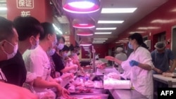 People buy items at a supermarket in Wuhan, China, August 2, 2021, as authorities said they would test its entire population for Covid-19 after the central Chinese city where the coronavirus emerged reported its first local infections in more than a year.
