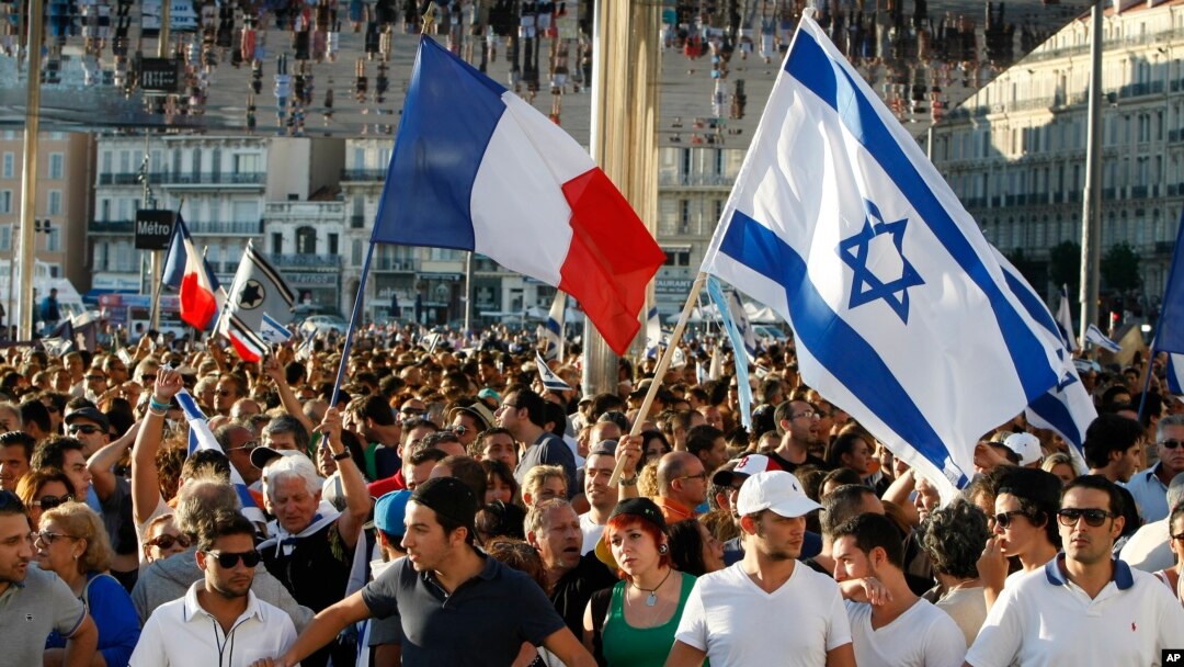 Supporters of Israel’s Gaza offensive wave Israeli and French flags at a demonstration in Marseille, France, July 27, 2014. The radical Jewish Defense League, not shown, uses strong-arm tactics to fight anti-Semitism.