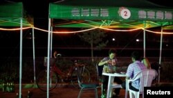 FILE PHOTO: A North Korean woman drinks beer at a local market in Rajin at the Special Economic Zone of Rason City, northeast of Pyongyang Aug. 29, 2011. 