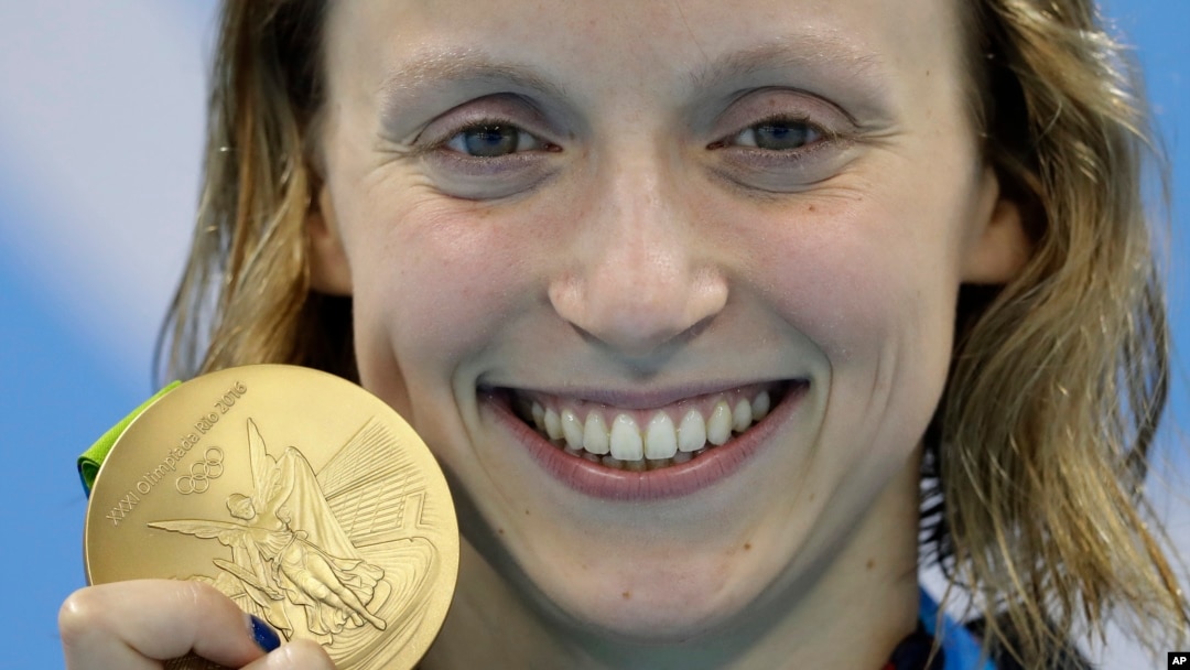 Katie Ledecky menunjukkan medali emasnya untuk nomor gaya bebas 800 meter putri di Rio de Janeiro, Brazil (12/8). 