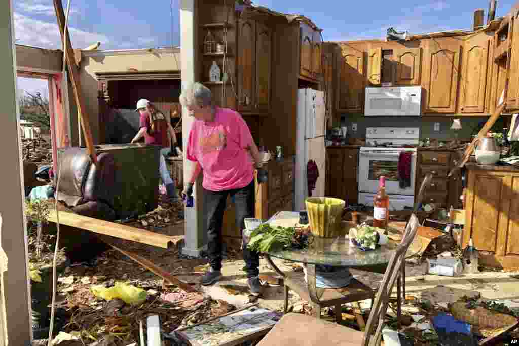 Patti Herring terisak-isak sambil memilah barang-barang rumah tangganya yang masih bisa diselamatkan di antara puing-puing rumahnya, pasca dihancurkan oleh tornado di Fultondale, Alabama, Selasa, 26 Januari 2021. (Foto: AP / Jay Reeves)