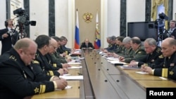 Russian President Vladimir Putin (C) attends a meeting with defence ministry officials in Moscow, May 30, 2012.