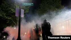 Agentes de las fuerzas del orden permanecen alerta durante la tercera noche de protestas en Kenosha, en Wisconsin, la noche del 25 de agosto de 2020.