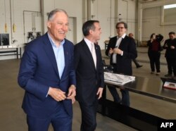 Democratic presidential hopeful Jay Inslee, who is the governor of Washington state, walks beside Los Angeles Mayor Eric Garcetti during a tour of the Los Angeles Department of Transportation bus depot in Los Angeles, May 3, 2019.