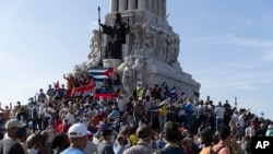 Pendukung pemerintah berkumpul di monumen Maximo Gomez di Havana, Kuba, Minggu, 11 Juli 2021. (AP Photo/Eliana Aponte). Pendukung pemerintah turun ke jalan saat ratusan lebih warga memprotes harga bahan makanan yang tinggi dan kurangnya persediaan pangan di Kuba.