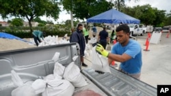 City workers load sandbags at a drive-thru sandbag distribution event for residents ahead of the arrival of rains associated with tropical depression Fred, Aug. 13, 2021, at Grapeland Park in Miami. 