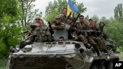 Ukrainian soldiers sit on top of an APC after a Ukrainian check was attacked by pro-Russians near the village of Blahodatne, eastern Ukraine, May 22, 2014.