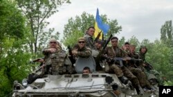 Ukrainian soldiers sit on top of an APC after a Ukrainian check was attacked by pro-Russians near the village of Blahodatne, eastern Ukraine, May 22, 2014.