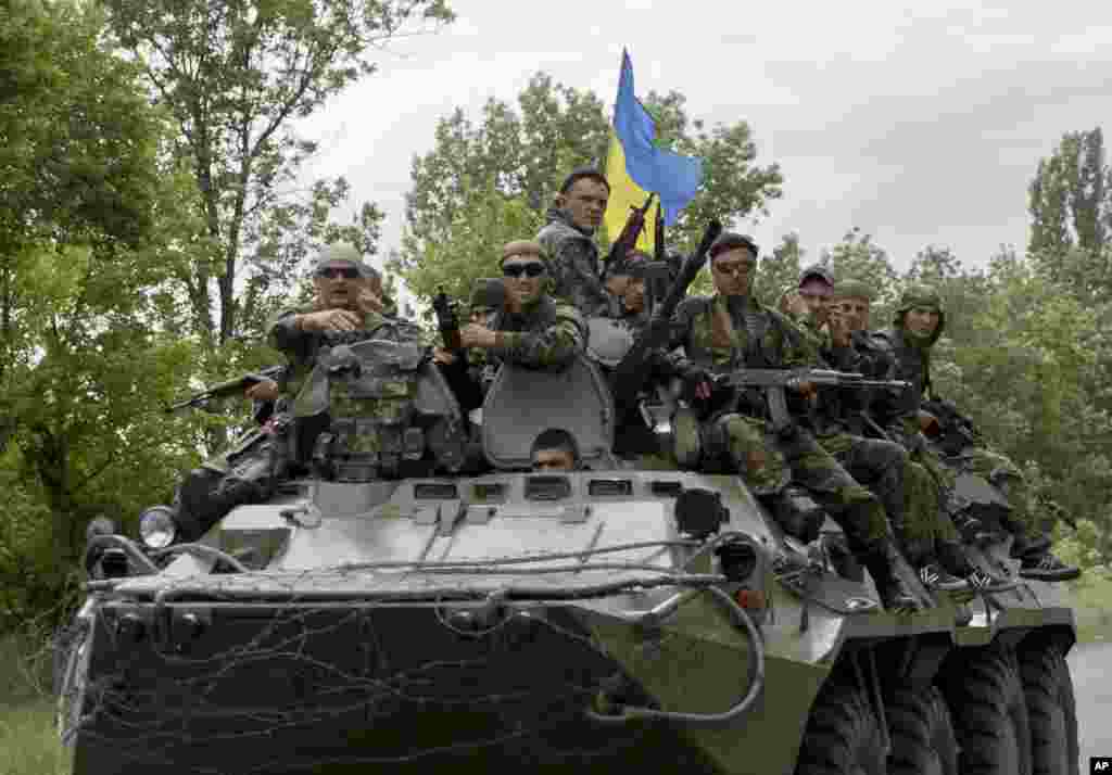 Ukrainian soldiers sit on top of an APC after a Ukrainian check was attacked by pro-Russians near the village of Blahodatne, eastern Ukraine, May 22, 2014.