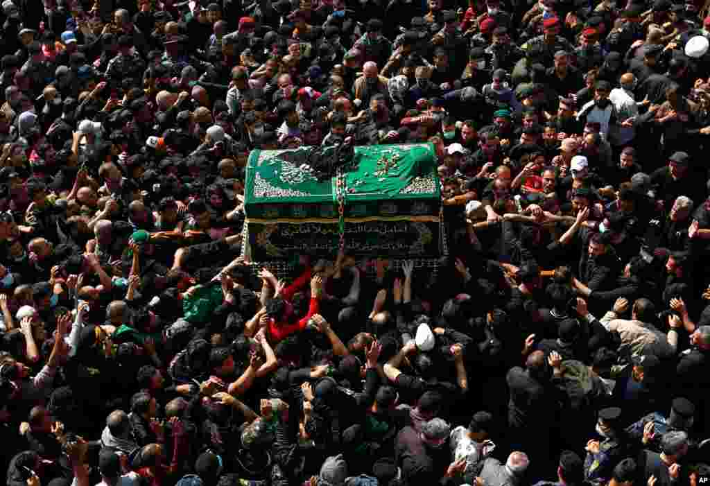 Shiite worshippers carry a symbolic coffin at the shrine of Imam Moussa al-Kadhim, who died at the end of the 8th century, during the yearly marking of his death, in Baghdad, Iraq.