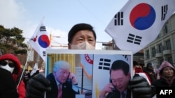 A supporter of impeached South Korean president Yoon Suk Yeol holds a placard of Yoon and incoming U.S. president Donald Trump that translates as “He responded by sending his special regards to the people of South Korea,” in Seoul on Jan. 6, 2025. 