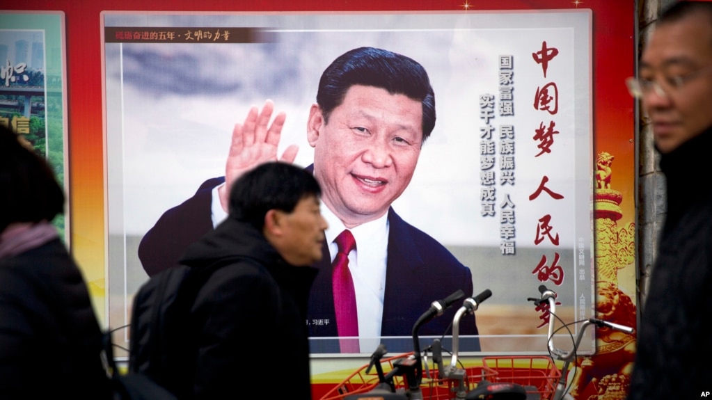 2018年3月2日，中国北京，人们走过展示中国国家主席习近平的宣传广告牌。(photo:VOA)