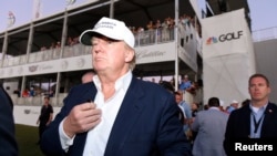 FILE - Republican presidential hopeful Donald Trump walks onto the 18th green for the awards ceremony following the final round at TPC Blue Monster at Trump National Doral earlier this year.