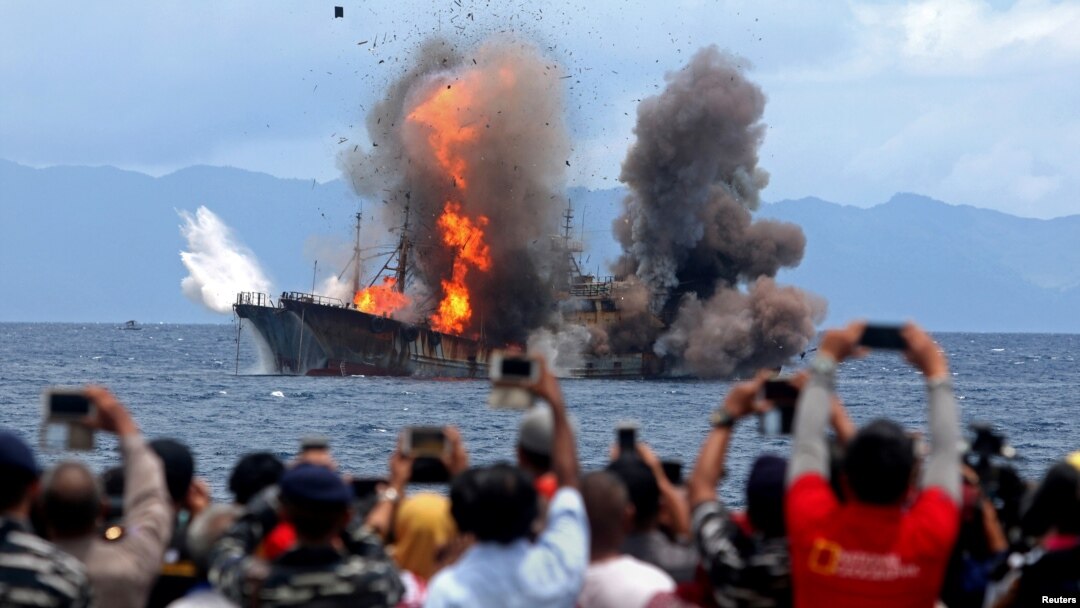 Warga mengambil gambar kapal ikan yang terbakar setelah pemerintah menghancurkan kapal-kapal asing yang tertangkap mencuri ikan di wilayah perairan Indonesia, di Desa Morela, P Ambon, 1 April 2017. (Antara Foto)