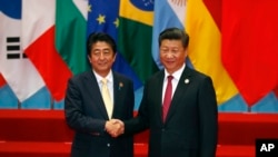 4일 중국 항저우에서 G20 정상회의 단체 기념촬영에 앞서 아베 신조 일본 총리(왼쪽)와 시진핑 중국 국가주석이 악수하고 있다. 두 정상은 5일 별도의 양자회담을 가졌다.