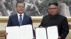 In this image made from video provided by Korea Broadcasting System (KBS), South Korean President Moon Jae-in, left, and North Korean leader Kim Jong Un pose after signing documents in Pyongyang, North Korea, Sept. 19, 2018.