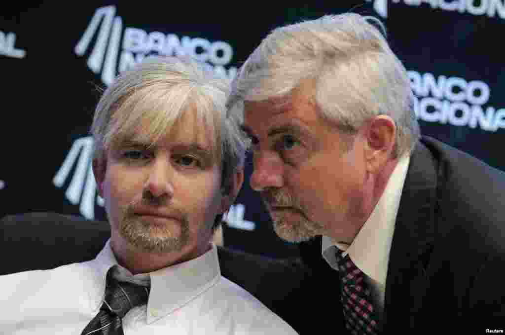 Danish scientist Henrik Scharfe (R) poses with his Geminoid-DK robot during its presentation at the National Robotics Olympiad in San Jose, Costa Rica, Aug. 16, 2013. The Geminoid-DK is a tele-operated Android in the geminoid series and is made to appear as an exact copy of its creator, Professor Scharfe.