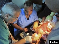 A child wounded by shelling is treated at a makeshift hospital at the Qusseer neighbourhood of Homs, July 18, 2012.