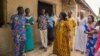 Rebecca Gadzama and schoolteachers survey the aging school building and discuss the upcoming school year.