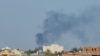 Smoke billows amid clashes between armed groups affiliated with Libya's Tripoli-based Government of National Unity (GNU) in the Libyan capital on August 15, 2023.