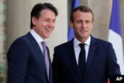 French president Emmanuel Macron, right, welcomes Italian Premier Giuseppe Conte before their meeting at the Elysee Palace in Paris, June 15, 2018. The two meet amid tensions between the two countries over migration.