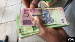 A man in Harare holds bondnotes issued by Reserve Bank of Zimbabwe, Oct. 15, 2018. The introduction of bond notes - a currency Zimbabwe started printing two years ago to ease the situation -- has not helped. (C.Mavhunga/VOA)