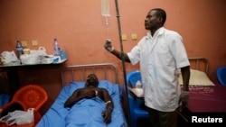 FILE - A doctor attends to a patient at a hospital in Accra, Ghana, June 5, 2015. 