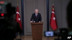 Turkey's President Recep Tayyip Erdogan talks to members of the media at the airport in Ankara, Turkey, before departing for a trip to France, Nov. 10, 2018.