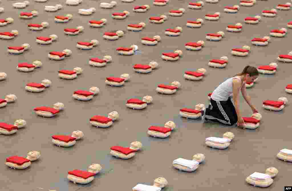 Seorang gadis mengatur boneka animasi di sebuah lapangan di Lingen, Jerman timur, menjelang upaya memecahkan rekor baru yang akan dilakukan bersama dengan sekitar 600 murid sekolah.