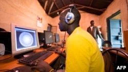FILE - Young men surf the internet at a cyber cafe on June 20, 2012 in Kibera slum in Nairobi. 