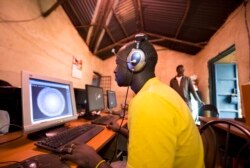 FILE - Young men surf the internet at a cyber cafe on June 20, 2012 in Kibera slum in Nairobi.