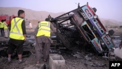 Pakistani volunteers search for blast victims in the wreckage of a destroyed passenger bus following a bomb explosion in Mastung district, about 25 kilometres south of Quetta, the capital of insurgency-hit Baluchistan province, September 18, 2012. 