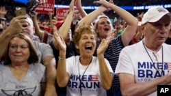 Les partisans du président Donald Trump, vêtus de Mike Braun pour le maillot du Congrès, se réjouissent de son arrivée à un meeting de campagne au Ford Center à Evansville.