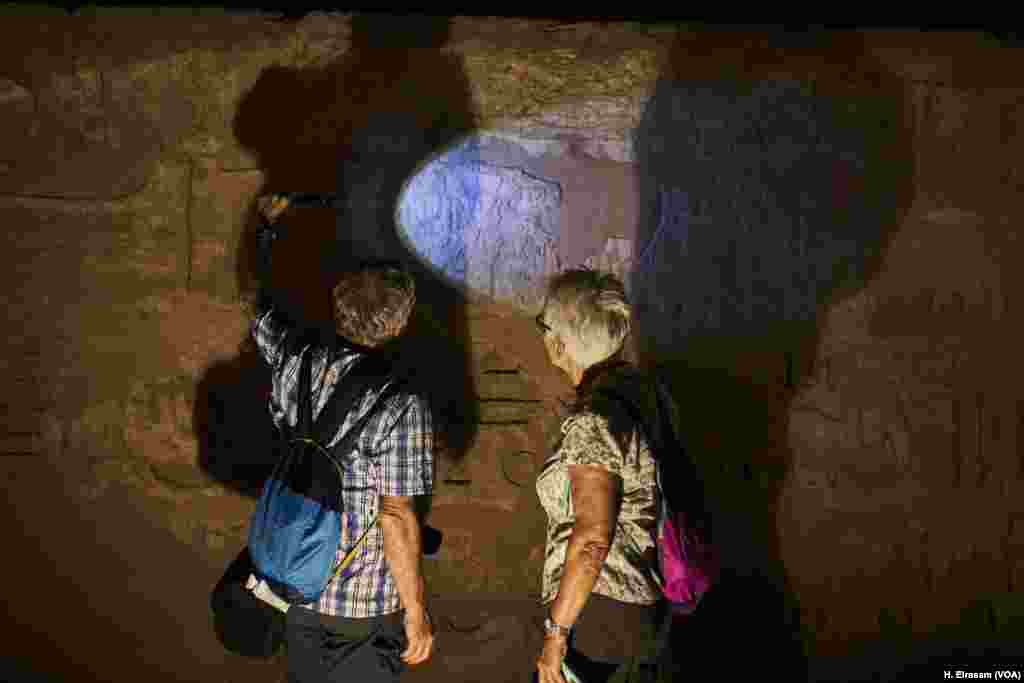 On World Heritage Day, a couple of tourists examine the reliefs on a wall after it was restored in Luxor temple in Egypt, April 20, 2018.