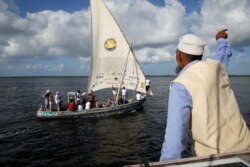 Ahli pembuat kapal, Ali Abdala Skanda, memberi isyarat kepada orang-orang di atas Flipflopi, perahu pertama yang seluruhnya terbuat dari daur ulang sampah plastik, seusai upacara peluncuran di pulau Lamu, Kenya, 15 September 2018. (REUTERS / Baz Ratner)