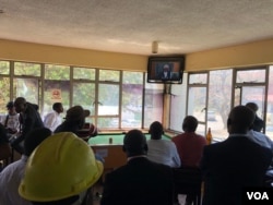 Zimbabweans are seen gathered at a bar in Harare, Aug. 22, 2018, where they are following proceedings on a presidential election challenge filed at the Constitutional Court by Zimbabwe's main opposition group. (C. Mavhunga/VOA)