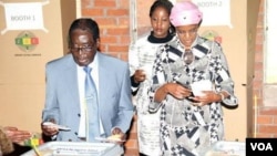 President Robert Mugabe voting in Harare's Highfield suburb Wednesday with his wife, Grace, and daughter Bona