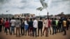 Les manifestants chantent l'hymne national congolais autour d'un rond-point à Beni lors d'une manifestation contre le report des élections sur le territoire des Beni et de la ville de Butembo le 27 décembre 2018.