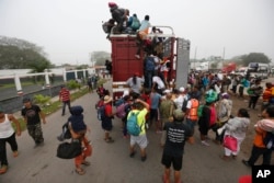 Central American migrants pack into the back of a trailer truck as they begin their morning trek as part of a thousands-strong caravan hoping to reach the U.S. border, in Isla, Veracruz state, Mexico, Sunday, Nov. 4, 2018.