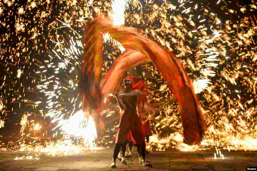 Performers take part in a fire dragon dance under a shower of molten iron sparks on the first day of the Chinese Lunar New Year of the Pig, in Zaozhuang, Shandong province, China, Feb. 5, 2019.