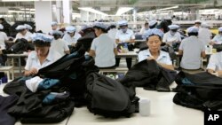FILE - North Korean workers assemble Western-style suits at the South Korean-run ShinWon Corp. garment factory inside the Kaesong industrial complex in Kaesong, North Korea.