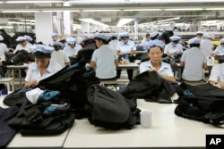 FILE - North Korean workers assemble Western-style suits at the South Korean-run ShinWon Corp. garment factory inside the Kaesong Industrial Complex in Kaesong, North Korea.
