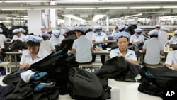 FILE - North Korean workers assemble Western-style suits at the South Korean-run ShinWon Corp. garment factory inside the Kaesong industrial complex in Kaesong, North Korea.