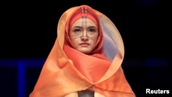 Seorang model membawakan karya siswa Sherly Az Zahra pada hari pertama Indonesia Muslim Fashion Show Festival di Jakarta, 4 April 2018. 