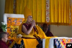 FILE - Tibetan spiritual leader the Dalai Lama wears the ceremonial hat of the Gelug school of the Tibetan Buddhism as he prays during his religious talk at the Tsuglakhang temple in Dharmsala, India, March 2, 2018.