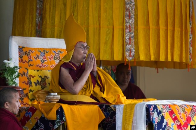 FILE - Tibetan spiritual leader the Dalai Lama wears the ceremonial hat of the Gelug school of the Tibetan Buddhism as he prays during his religious talk at the Tsuglakhang temple in Dharmsala, India, March 2, 2018.