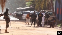 Warga setempat berlarian menyelamatkan diri dari hotel Radisson Blu Hotel di Bamako, Mali (20/11).