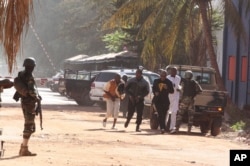 People run to flee from the Radisson Blu Hotel in Bamako, Mali, Nov. 20, 2015.
